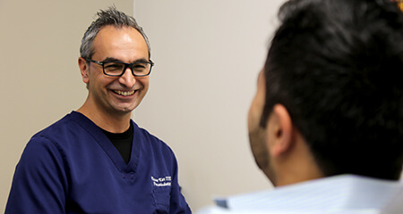 Dr. Kar smiling at dental patient