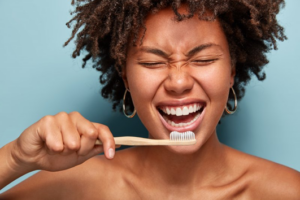 Woman brushing her teeth and flashing a smile